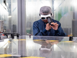 Zheng Wei looking through an optical device in the lab